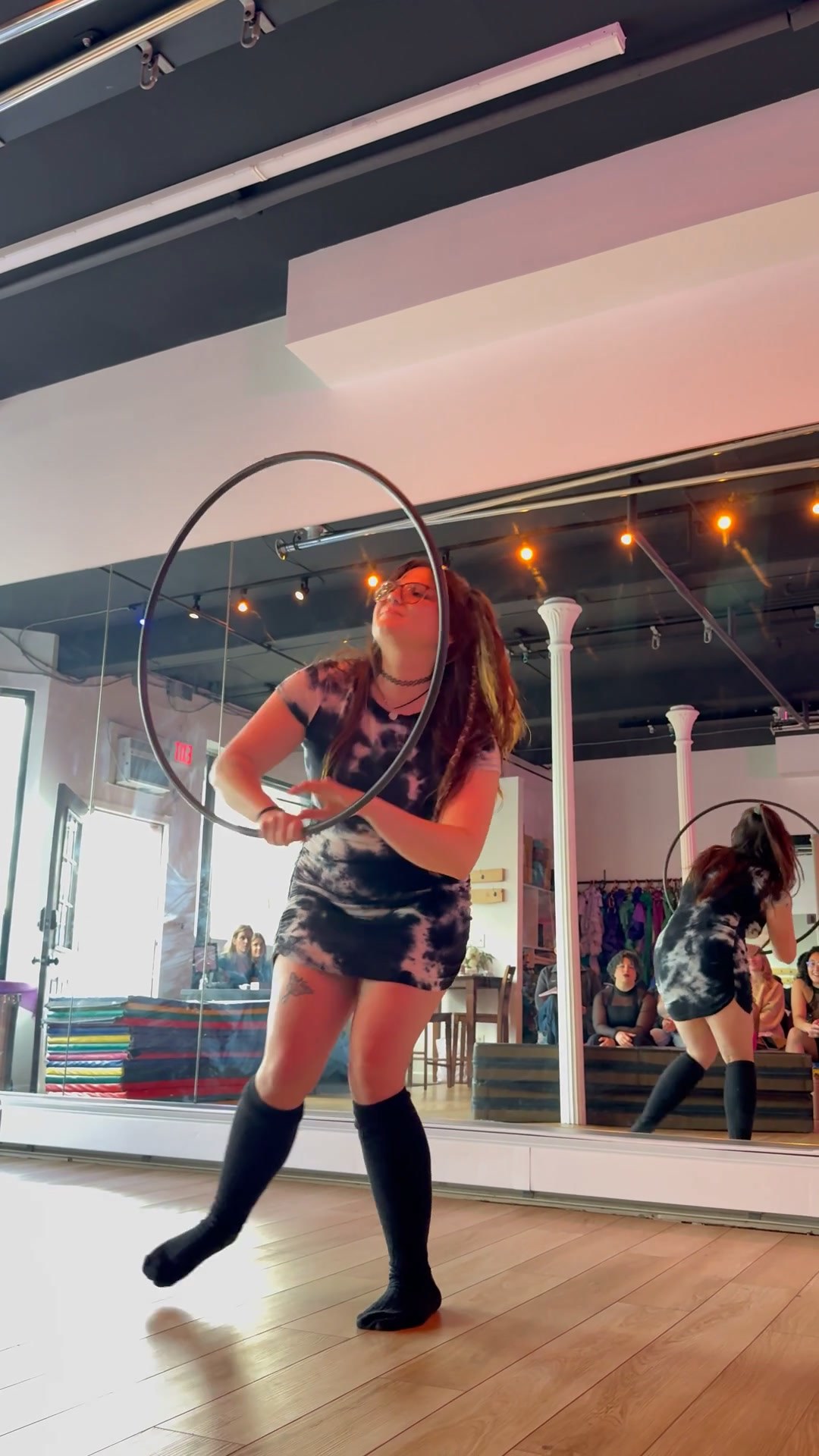 Instructor Lauren dancing with a spinning hula hoop during a circus flow arts class in Chester, NY